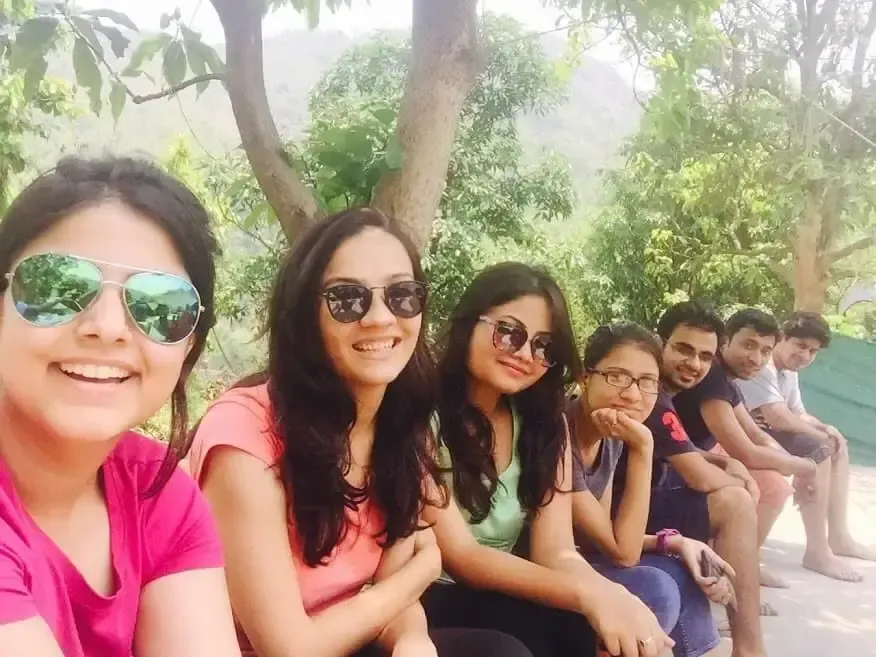 Supplymint team members sitting under a tree during an outdoor team trip